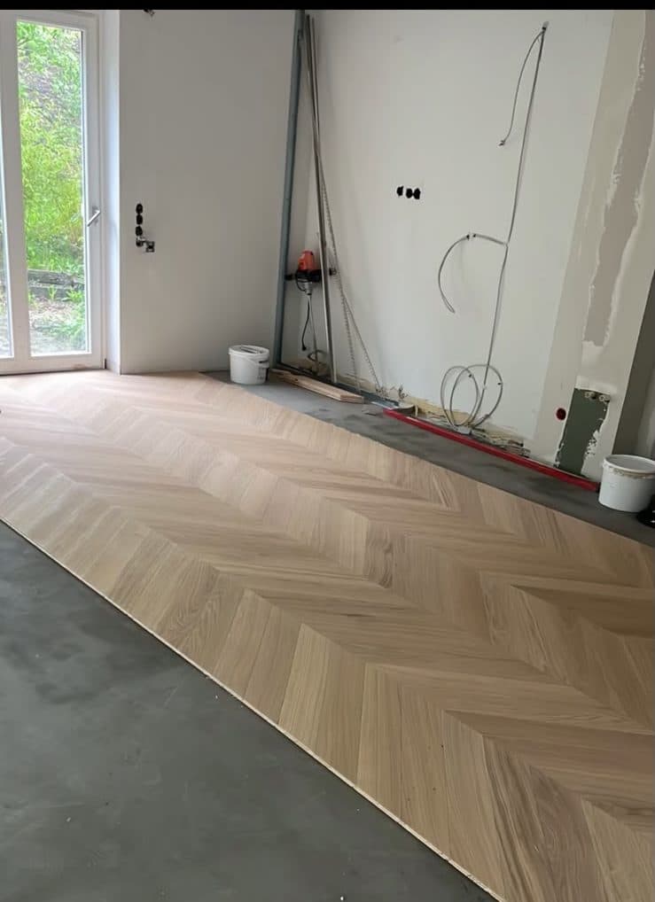 Chevron-Parkett aus heller Eiche wird in einem Neubau in Wuppertal verlegt