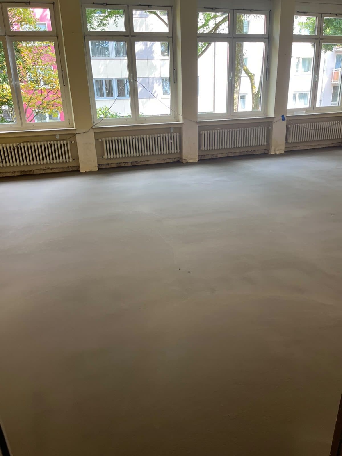 Fertig nivellierter, ebener Estrich in einem Altbaubüro, bereit für den neuen Bodenbelag
