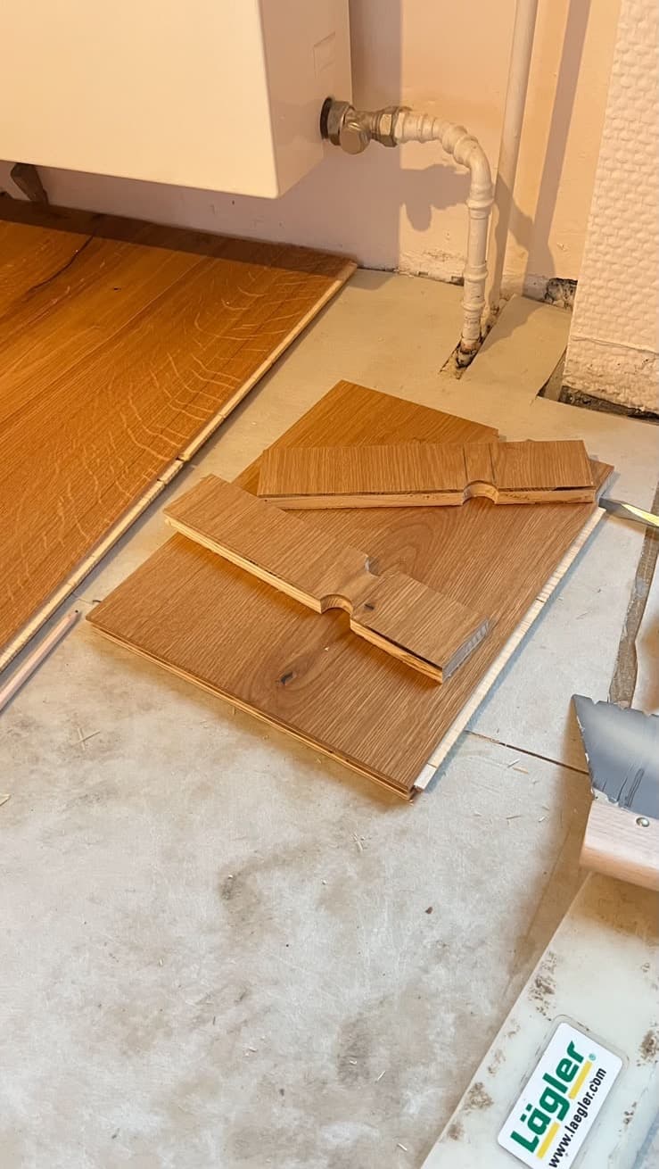 Parkettdielen mit vorbereiteten Aussparungen für das Heizungsrohr